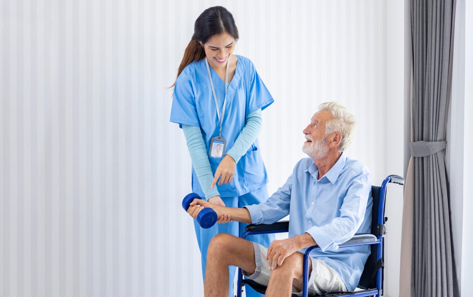 Hospice nurse is helping Caucasian man in wheelchair to exercisi Hospice nurse is helping Caucasian man in wheelchair to exercising muscle strength at pension retirement center for home care rehabilitation and post treatment recovery process