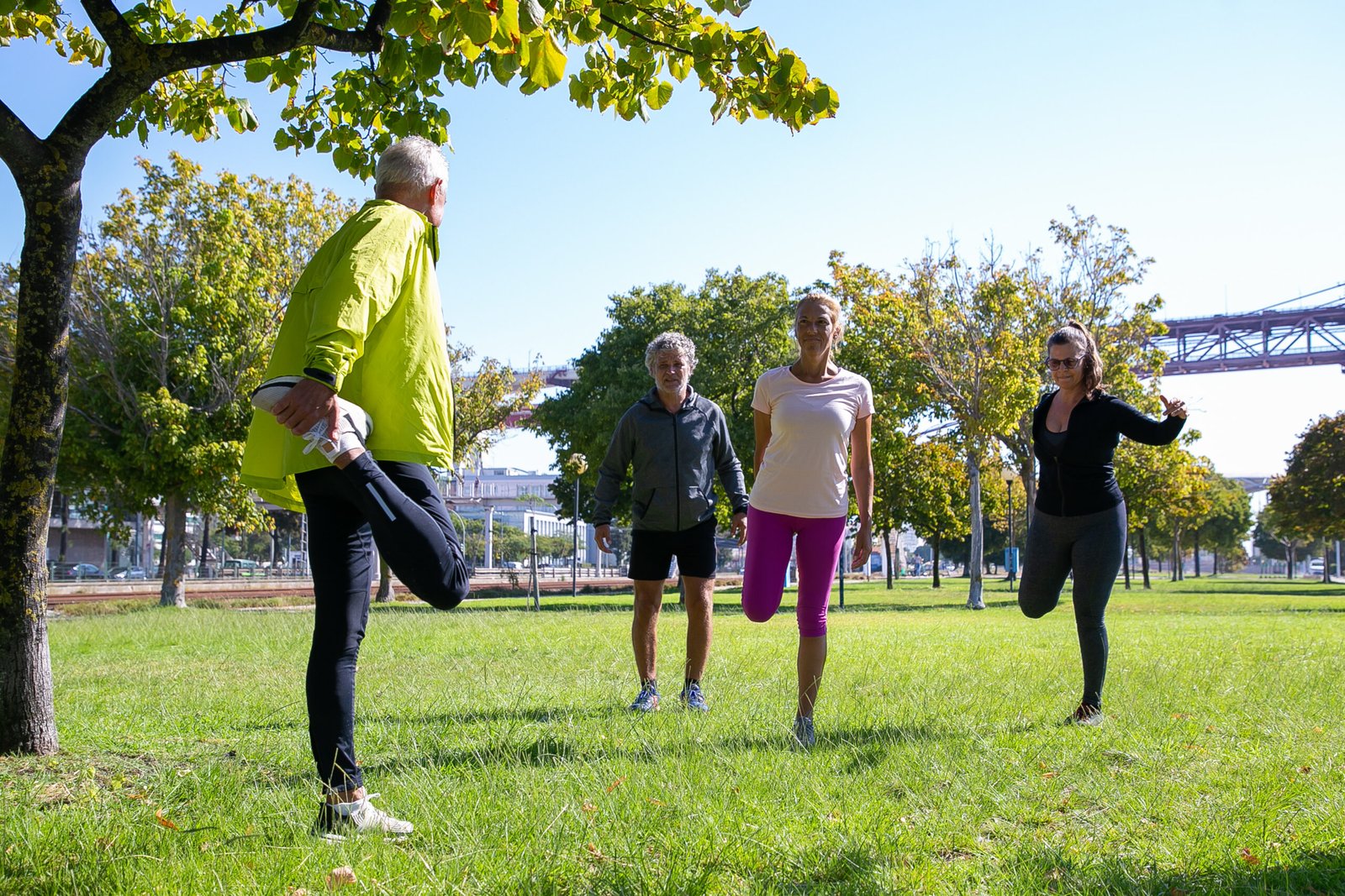 Group of retired active mature people wearing sports clothes Group of retired active mature people wearing sports clothes, doing morning exercise on park grass. Retirement or active lifestyle concept